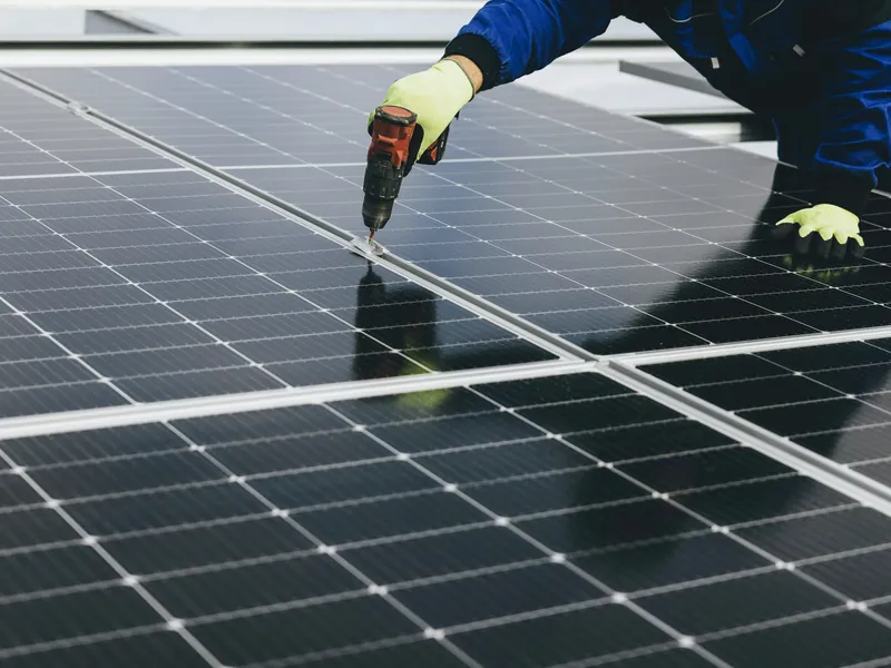 Monteur legt zonnepanelen op een schuin dak